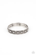 Load image into Gallery viewer, Dotted with dainty white rhinestone centers, floral filigree embossed silver frames are threaded along stretchy bands around the wrist for a romantic pop of color.
