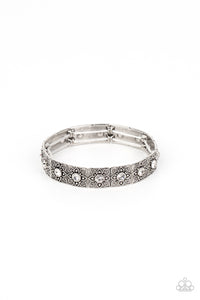 Dotted with dainty white rhinestone centers, floral filigree embossed silver frames are threaded along stretchy bands around the wrist for a romantic pop of color.