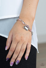 Load image into Gallery viewer, Encased in sleek silver fittings, classic white rhinestones and emerald cut pink rhinestones delicately link into a sparkly chain around the wrist. A shiny silver heart charm swings from the glittery compilation, adding a flirtatious shimmer. Features an adjustable clasp closure.
