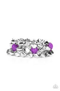 Infused with pops of purple accents, a faceted series of silver beads are threaded along stretchy bands around the wrist for a flashy fashion.