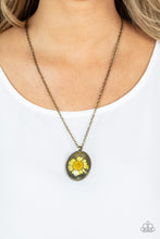 Load image into Gallery viewer, Featuring a rustic brass backdrop, a yellow daisy is encased inside a glassy brass frame at the bottom of an antiqued brass chain for a romantically rustic look. Features an adjustable clasp closure.
