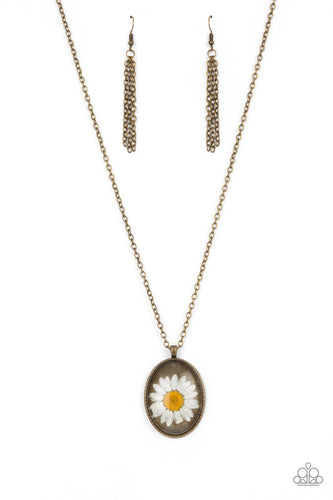 Featuring a rustic brass backdrop, a white daisy is encased inside a glassy silver frame at the bottom of an antiqued brass chain for a romantically rustic look. Features an adjustable clasp closure. 