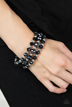 Load image into Gallery viewer, Varying in size, and explosion of metallic blue crystal-like gems and ornate silver beads are threaded along stretchy bands around the wrist for a glamorous fashion.
