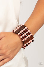 Load image into Gallery viewer, Colorful layers of brown and Pale Rosette wooden beads are threaded along stretchy bands between brown wooden bars creating stacks of subtle bliss around the wrist.
