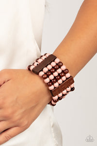 Colorful layers of brown and Pale Rosette wooden beads are threaded along stretchy bands between brown wooden bars creating stacks of subtle bliss around the wrist.