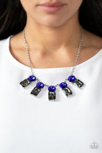 Load image into Gallery viewer, A sparkly row of oversized blue gems regally sit atop emerald cut smoky rhinestone bases as they delicately link along a dainty silver chain below the collar, resulting in a royal glamorous centerpiece. Features an adjustable clasp closure.
