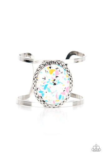 Featuring a colorful terrazzo finish, an oversized multi-colored stone is pressed into the center of a hammered silver frame atop a layered silver cuff for a modern stone look. 