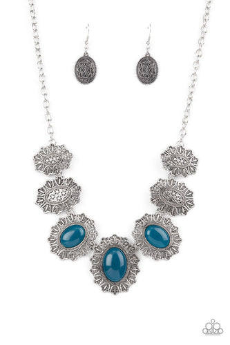 Filled with rustic filigree, scalloped silver frames gradually increase in size as they link below the collar. Three oversized oval Mykonos Blue beads adorn the centermost frames, adding an ethereal pop of color to the whimsical display. Features an adjustable clasp closure.