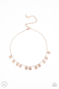 A dainty collection of mandala-like rose gold discs swings from a shiny rose gold chain, creating a shimmery radiance around the neck. Features an adjustable clasp closure.