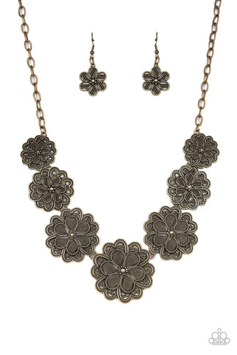 Featuring metallic wicker-like patterns, stacks of teardrop and heart shaped filigree-filled brass petals delicately link into a decorative row of flowers. The floral frames gradually increase in size as they move towards the center, creating a vintage inspired display below the collar. Features an adjustable clasp closure.