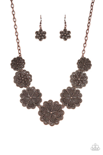 Featuring metallic wicker-like patterns, stacks of teardrop and heart shaped filigree-filled copper petals delicately link into a decorative row of flowers. The floral frames gradually increase in size as they move towards the center, creating a vintage inspired display below the collar. Features an adjustable clasp closure. 