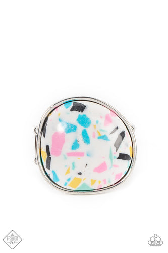 Featuring colorful flecks of blue, pink, yellow, and black, an asymmetrical round terrazzo stone is pressed into a simple silver frame creating a funky style atop the finger. Features a stretchy band for a flexible fit.  Sold as one individual ring.  New Kit Fashion Fix