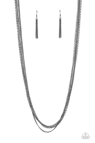 Mismatched strands of extended gunmetal chains layer with a glitzy row of dainty white rhinestones across the chest, resulting in an edgy industrial centerpiece. Features an adjustable clasp closure.