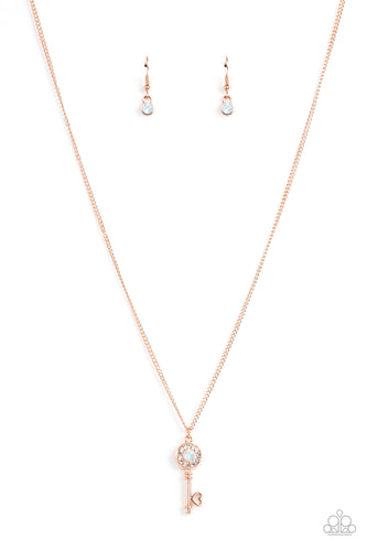 Bordered in glassy white rhinestones, an opal white rhinestone adorns a shiny copper key pendant at the bottom of a dainty shiny copper chain for a whimsical fashion. Features an adjustable clasp closure.