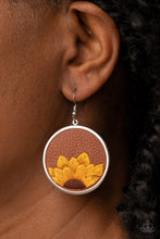 Load image into Gallery viewer, A golden yellow and brown threaded sunflower is stitched into the bottom of a brown leather frame that is encased in a sleek silver frame, resulting in a whimsical floral fashion. Earring attaches to a standard fishhook fitting.
