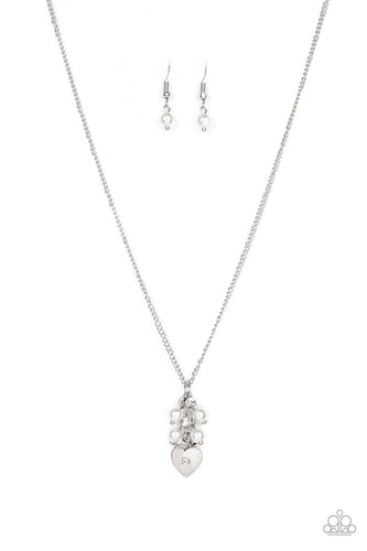 Dotted with a dainty white rhinestone, a shiny silver heart swings from the bottom of a bubbly cluster of white pearls and white rhinestones, creating a locket inspired pendant below the collar. Features an adjustable clasp closure. 