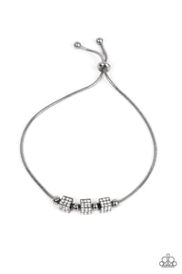 Dainty gunmetal beads and white rhinestone encrusted gunmetal cubes slide along a rounded gunmetal snake chain around the wrist, resulting in a radiant centerpiece. Features an adjustable sliding bead closure. 