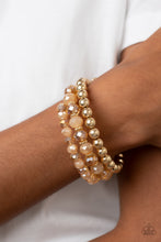 Load image into Gallery viewer, Sections of glistening gold beads and an alternating pattern of golden and iridescent flecked gems gradually increase in size along a coiled wire, creating a jaw-dropping infinity wrap bracelet around the wrist.
