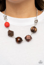 Load image into Gallery viewer, Infused with a solitaire red wooden bead, a mismatched assortment of studded silver hoops, textured silver rings, and oversized brown wooden beads delicately connect across the chest for a stylishly handcrafted fashion. Features an adjustable clasp closure.
