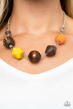 Load image into Gallery viewer, Infused with yellow and orange wooden beads, a mismatched assortment of studded silver hoops, textured silver rings, and oversized brown wooden beads delicately connect across the chest for a stylishly handcrafted fashion. Features an adjustable clasp closure.
