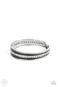 Two elongated flared frames painted in a glossy black finish connect at their tapered ends to a hinge. A row of rhinestones runs down the center of each frame, adding blinding sparkle to the piece, as the subtle studded borders of the frames add a hint of edge. Features a hinged closure.  Sold as one individual bracelet.