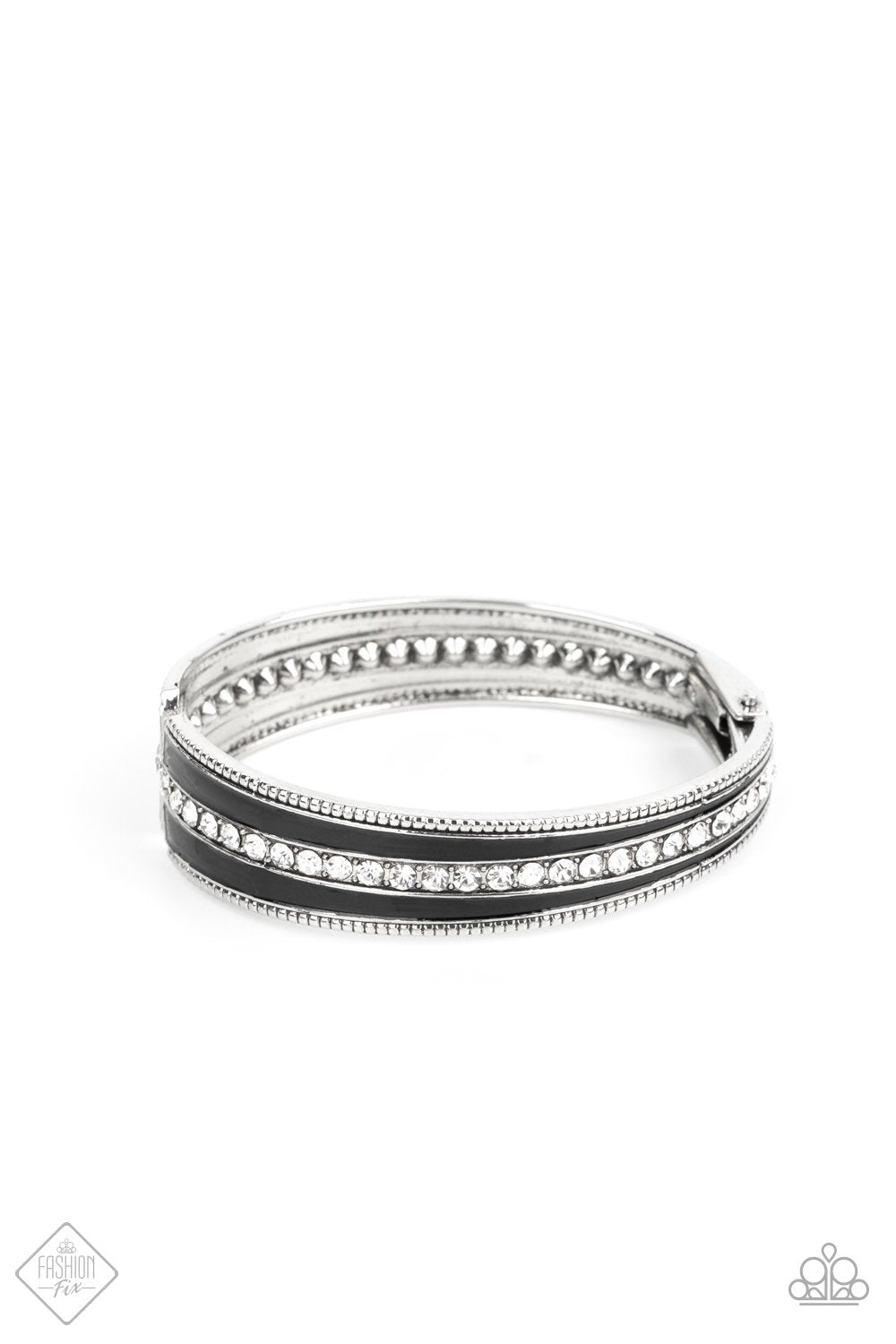 Two elongated flared frames painted in a glossy black finish connect at their tapered ends to a hinge. A row of rhinestones runs down the center of each frame, adding blinding sparkle to the piece, as the subtle studded borders of the frames add a hint of edge. Features a hinged closure.  Sold as one individual bracelet.