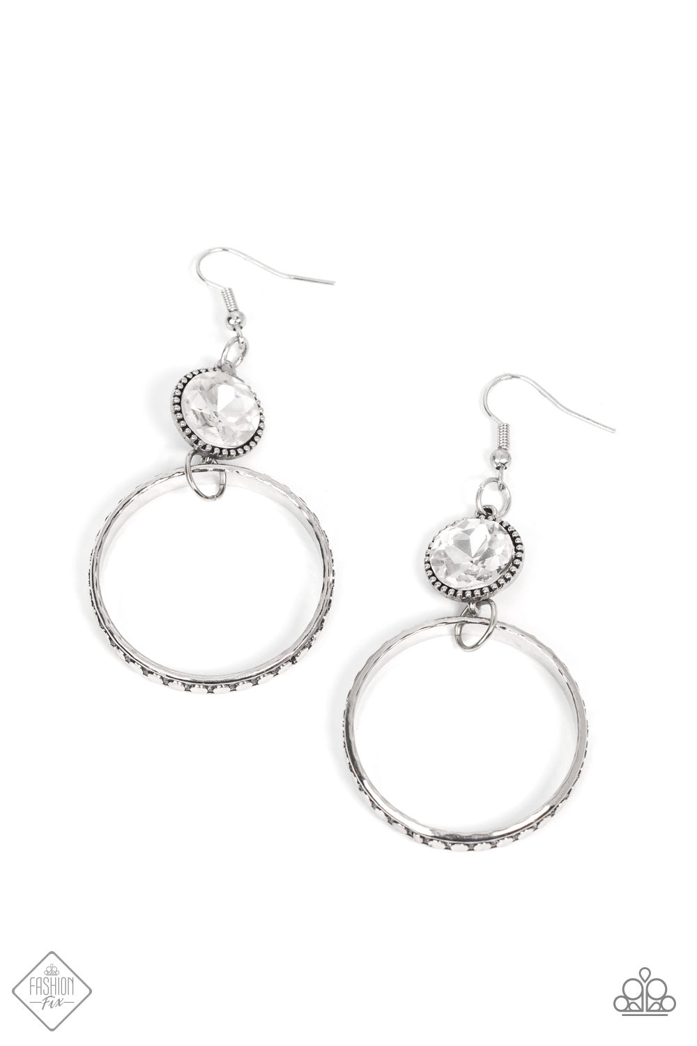 The outer edge of a silver ring is stamped with a flattened dot motif as it swings below a dramatic white rhinestone that sparkles inside a daintily dotted antiqued silver frame, creating an upscale, edgy modern lure. Earring attaches to a standard fishhook fitting.  Sold as one pair of earrings.  Fashion Fix