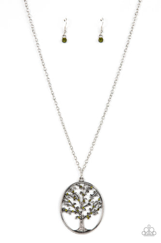 Dainty green rhinestones are sprinkled across the top of a silver tree beautifully branching inside an oval silver frame, resulting in a seasonal pendant at the bottom of an extended silver chain. Features an adjustable clasp closure. 