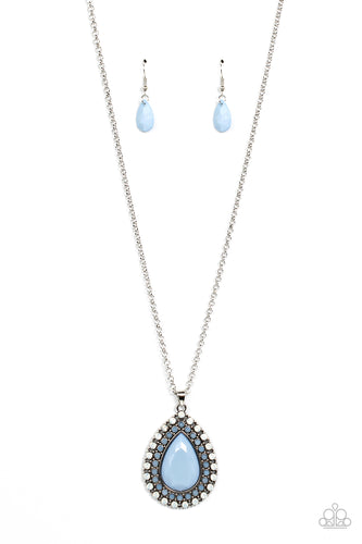 A faceted blue teardrop is pressed into the center of a silver frame bordered in rows of opalescent white and blue beads, creating an ethereal pendant at the bottom of a classic silver chain. Features an adjustable clasp closure. 