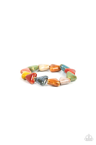 Painted in distressed multicolored finishes, ceramic beads shaped like shark teeth are threaded along a stretchy band around the wrist for a seasonal flair. 
