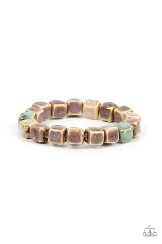 Featuring distressed purple, blue, and brown glazed finishes, a rustic collection of ceramic cube beads are threaded along stretchy bands around the wrist for a colorful flair. Due to the nature of the materials, some color variation is normal. 