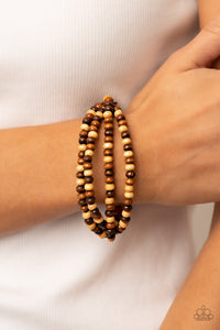 Varying in natural wooden finishes, stretchy strands of dainty wooden beads attach to a single row of oversized wooden beads around the wrist for an earthy spin on the homespun trend.