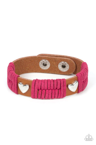 Sections of pink suede laces wrap around spliced sections of a brown leather band. A pair of silver heart frames stud the front of the band, adding romantic charm to the rustic centerpiece. Features an adjustable snap closure.
