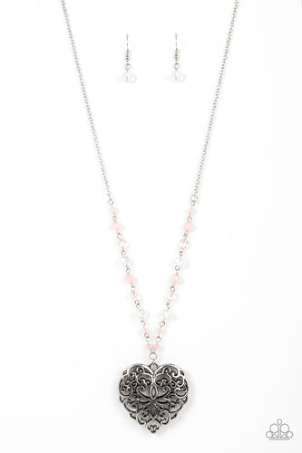 Featuring opaque and glassy crystal-like finishes, a dainty collection of Pale Rosette and white beads gives way to an oversized filigree filled heart frame, creating an antiqued locket inspired pendant at the bottom of a lengthened silver chain. Features an adjustable clasp closure.