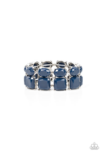 Separated by pairs of dainty silver beads, faceted stacks of oval and square cut blue beads are threaded along a stretchy band around the wrist for a refreshing pop of color.