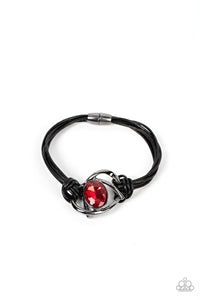 Shiny gunmetal bars abstractly twist around an oversized oval red gem, resulting in a mesmerizing centerpiece that is knotted in place with layers of black leather cording. Features a magnetic closure.