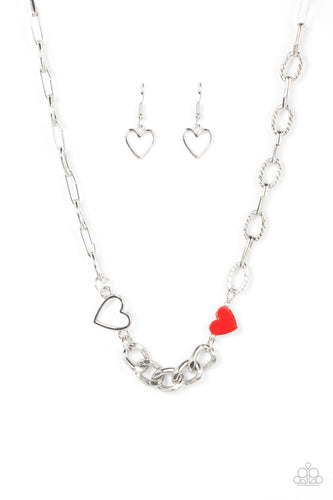A pair of shiny silver and red hearts asymmetrically adorn sections of mismatched silver chain, resulting in a flirtatious pop of color below the collar. Features an adjustable clasp closure.
