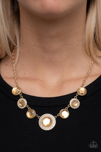 Oversized golden gems alternate with matching gems bordered in rings of glassy white rhinestones below the collar, resulting in a spellbinding sparkle at the bottom of a classic gold chain. Features an adjustable clasp closure. 