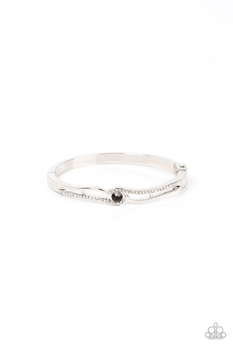 Ribbons of shiny silver and white rhinestone encrusted silver bars wrap around a glittery purple rhinestone center, resulting in a timeless shimmer atop a versatile bangle-like bracelet. Features a hinge closure.