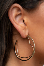 Load image into Gallery viewer, A gold wire heart is encircled in an oversized gold hoop, resulting in a heart-stopping shimmer. Earring attaches to a standard post fitting. Hoop measures approximately 2&quot; in diameter.
