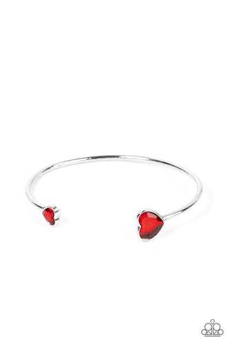 Enhanced with glitzy red rhinestones, two silver hearts adorn the ends of a silver band that curls around the wrist for a flirtatious open-faced style cuff. 
