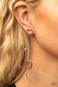 Encrusted in dainty red rhinestones, a glittery silver heart fitting attaches to a double-sided post designed to fasten behind the ear. Attached to dainty silver chains of varying lengths, a glittery collection of pink and red rhinestone dotted heart frames cascades out from behind the ear for a heart-stopping sparkle. Earring attaches to a standard post fitting.