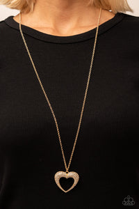 A flared gold heart is encrusted in glassy white rhinestones, resulting in a romantic shimmer at the bottom of an extended shiny copper chain. Features an adjustable clasp closure.