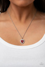 Load image into Gallery viewer, Bordered in stacked rows of glassy white rhinestones, a fiery red heart shaped gem sparkles at the center of a dainty silver chain for a flirtatious fashion. Features an adjustable clasp closure. 
