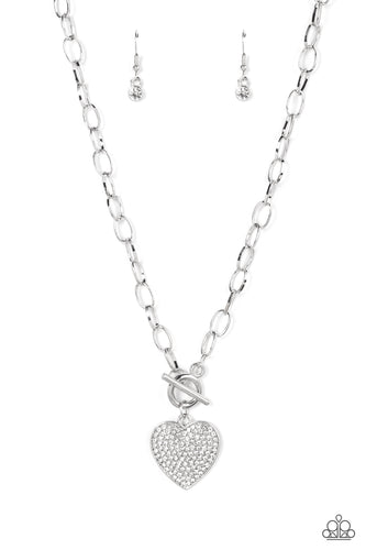 A white rhinestone dotted silver heart frame sparkles from a toggle closure at the center of an oval silver linked chain for a flirtatious fashion. Features a toggle closure.