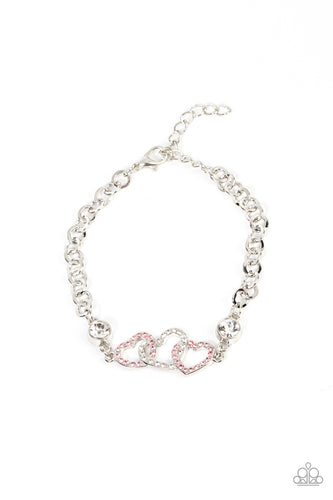 Pink and white rhinestone dotted hearts delicately interlock between two white rhinestone fittings, creating heart-pounding sparkle atop the wrist. Features an adjustable clasp closure.