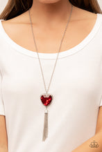 Load image into Gallery viewer, Bordered in a ribbon of glassy white rhinestones, an oversized red heart-shaped gem seemingly floats at the bottom of an extended silver chain. A shimmery silver chain tassel dances from the bottom of the sparkly pendant for a flirtatious finish. Features an adjustable clasp closure. 
