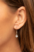 Load image into Gallery viewer, Bordered in a ribbon of glassy white rhinestones, an oversized red heart-shaped gem seemingly floats at the bottom of an extended silver chain. A shimmery silver chain tassel dances from the bottom of the sparkly pendant for a flirtatious finish. Features an adjustable clasp closure. 
