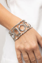 Load image into Gallery viewer, Dotted with dainty topaz rhinestones, an airy collection of hammered circular and rectangular frames glides along stretchy bands around the wrist. The geometric frames are separated by trios of dainty silver cube beads, adding extra edge to the textured display.
