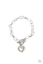 Load image into Gallery viewer, Bordered in glassy white rhinestones, a white heart shaped gem sparkles from a toggle closure at the center of an oval silver linked chain for a flirtatious fashion around the wrist. Features a toggle closure.
